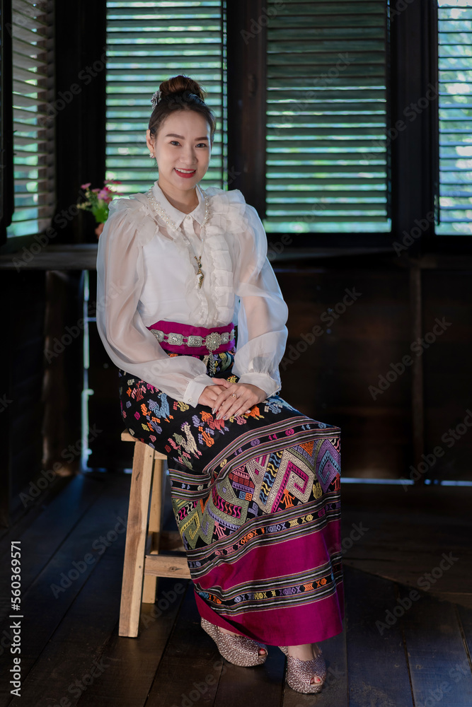 Tourist an Asian Thai woman dressed in traditional Thai dress at the old house in Lampang, Thailand. Retro fashion style concept.