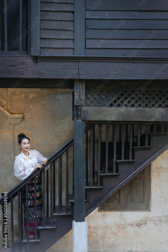 Tourist an Asian Thai woman dressed in traditional Thai dress at the old house in Lampang, Thailand. Retro fashion style concept. Tourist an Asian Thai woman dressed in traditional Thai dress at the old house in Lampang, Thailand. Retro fashion style concept.