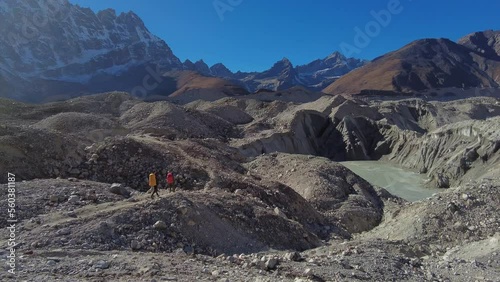 Ngozumpa, Nepal: Panoramic view of hikers crossing the Ngozumpa glacier between Cho La pass and Gokyo in the Himalayas in Nepal with Cho Oyu in the background.  photo