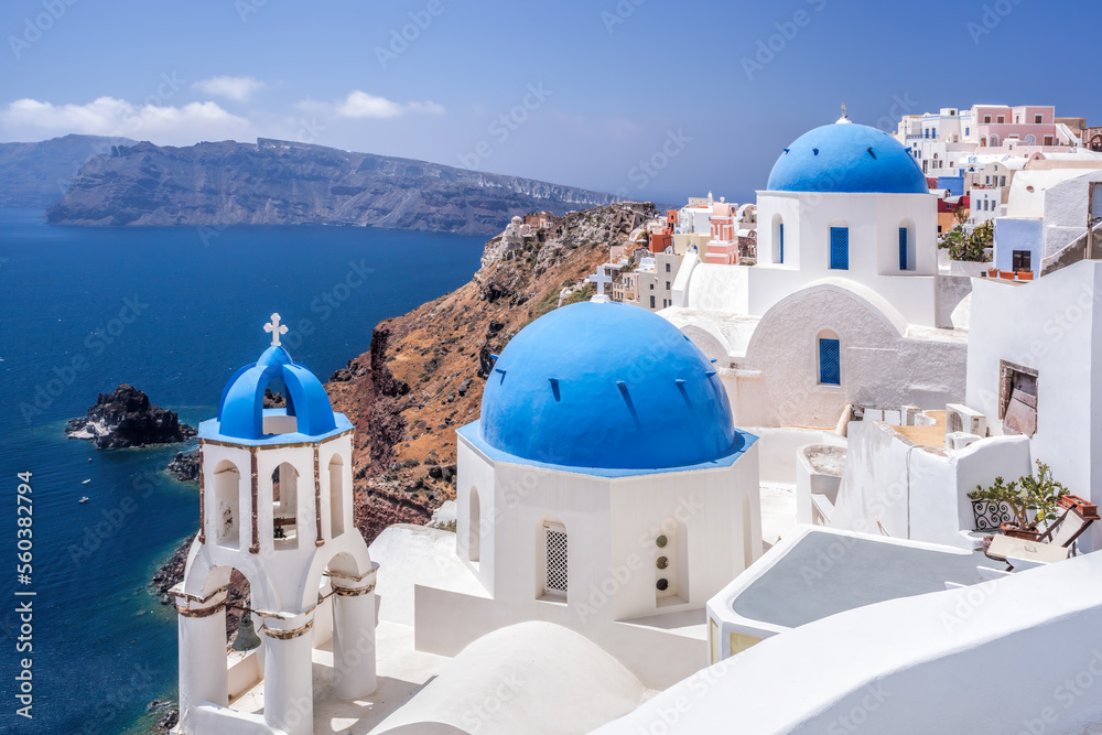 Oia village with churches against Aegean sea on Santorini island in Greece