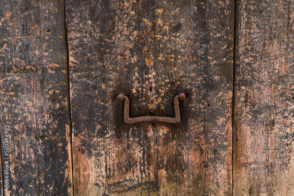 old weathered background of a wooden window shutter with metal handle 