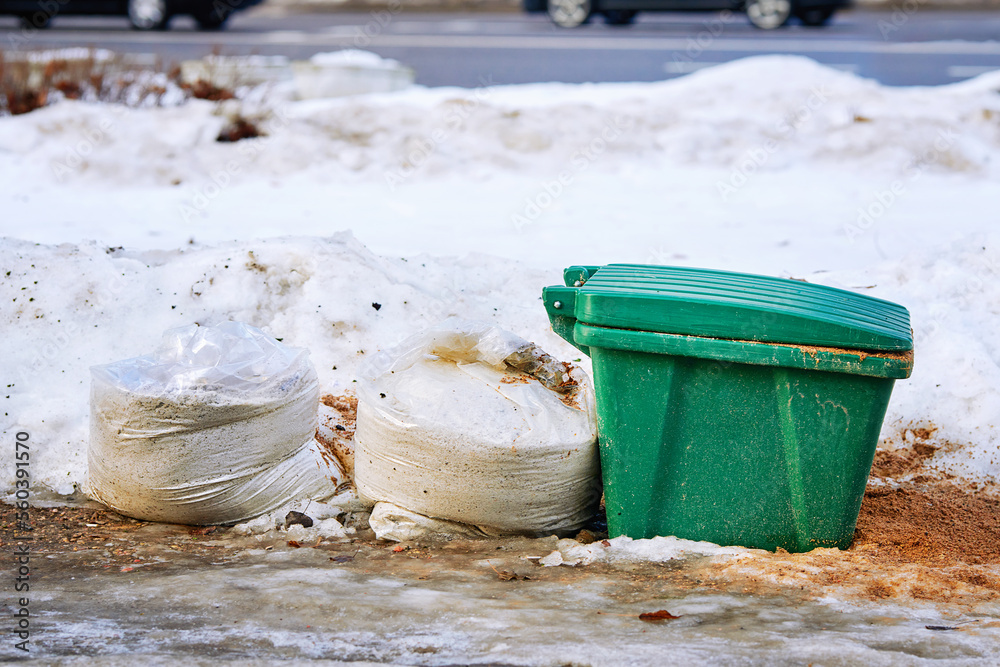 Foto de Grit bin and salt plastic bags, sand and salt mixture for