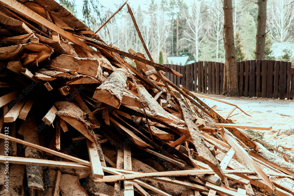 Woodpile with planks and boards waste stacked in heap near sawmill Woodpile with planks and boards waste stacked in heap near sawmill
