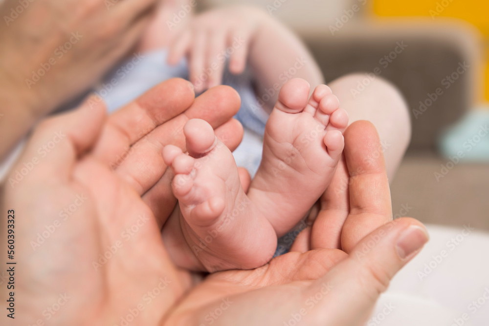 Close - Up of mother cradling her baby boy's feet