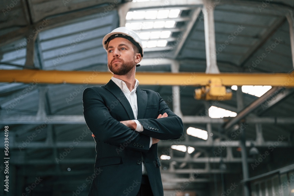 Serious manager in black formal wear is at the factory Serious manager in black formal wear is at the factory