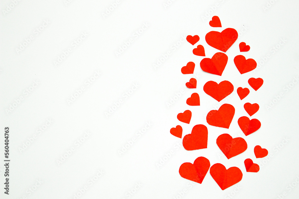 Valentine’s day background. Red hearts isolated on white. Love-shaped paper-cut decorations for International Women’s Day or Mother’s Day. Flat lay. Left copy space