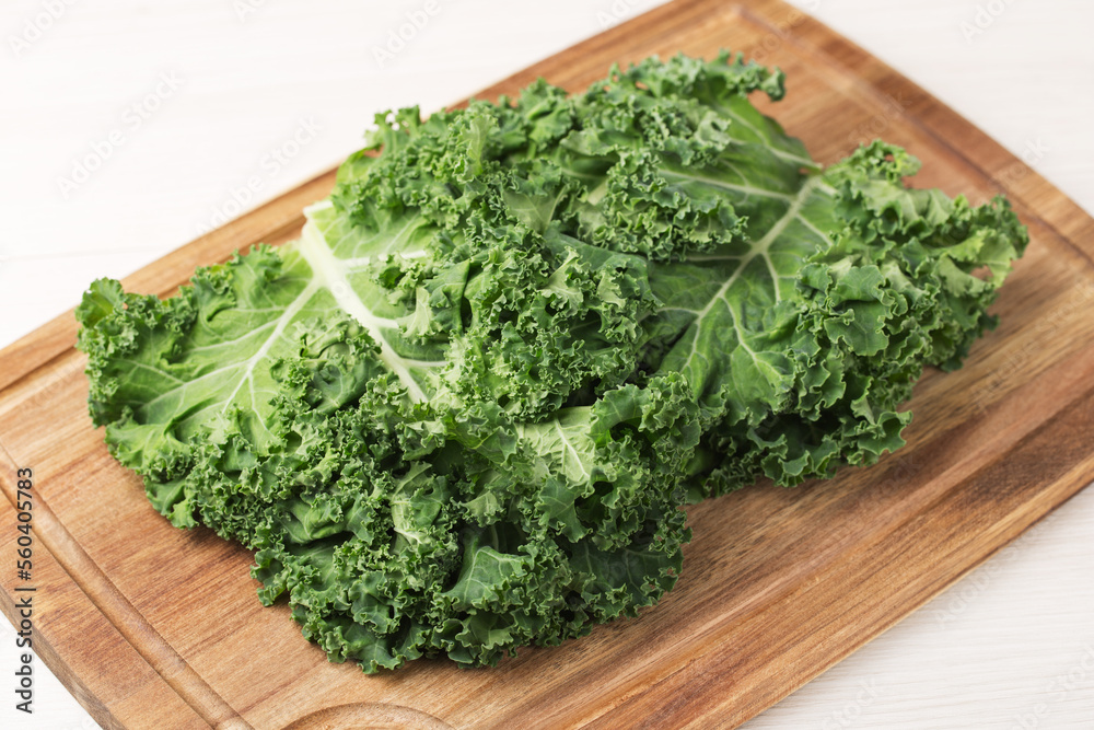 Fresh Curly Kale leaves on a wooden cutting board. Healthy eating concept. Superfoods. Organic food. Fresh Curly Kale leaves on a wooden cutting board. Healthy eating concept. Superfoods. Organic food.