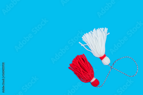 Traditional Martisor - symbol of holiday 1 March  Martenitsa  Baba Marta  beginning of spring and seasons changing in Romania  Bulgaria  Moldova. Greeting and post card for holidays. Blue background.