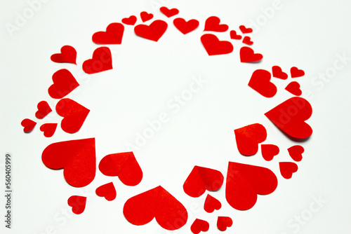 Valentine’s day background. Red hearts in a circle shape isolated on white. Love-shaped paper-cut decorations for International Women’s Day or Mother’s Day. Flat lay. Copy space