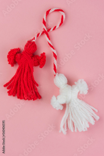 Traditional Martisor - symbol of holiday 1 March, Martenitsa, Baba Marta, beginning of spring and seasons changing in Romania, Bulgaria, Moldova. Greeting and post card for holidays. Pink background.