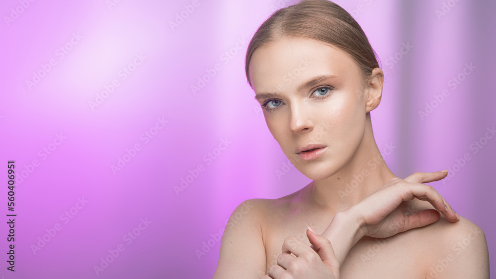 Naklejka premium Beauty and skin care. Happy woman with fresh radiant, moisturized skin, standing with bare shoulders, with light makeup and natural skin on a pink background.