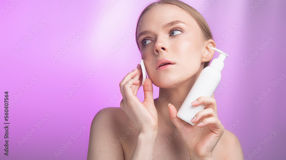 woman applying cream on face.Beauty and skin care. Happy woman with fresh radiant, hydrated skin standing with bare shoulders taking care of her skin. feels happy and confident on a pink background. woman applying cream on face.Beauty and skin care. Happy woman with fresh radiant, hydrated skin standing with bare shoulders taking care of her skin. feels happy and confident on a pink background.