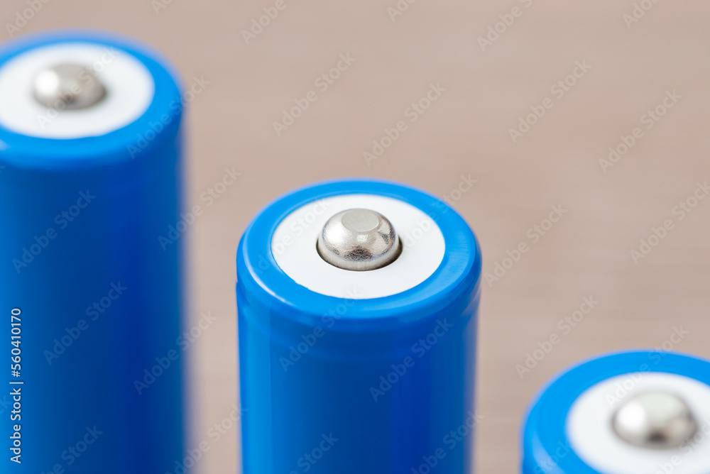 Close up of three rechargeable batteries. Generic 18650 battery, positive polarity clamp exposed Close up of three rechargeable batteries. Generic 18650 battery, positive polarity clamp exposed