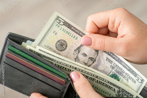 Woman gets american money from the wallet, close up. World currency, dealing with dollars, business and purchases concept