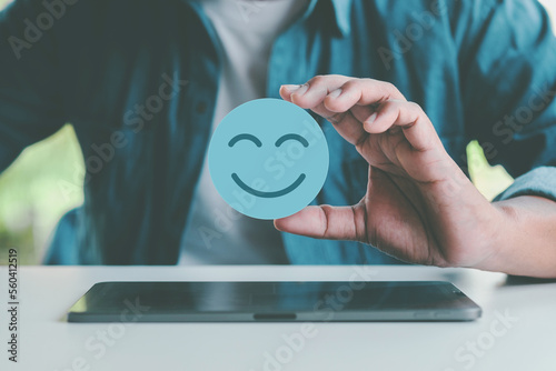 Hand holding blue paper cut happy smile face, positive thinking, mental health assessment , world mental health day concept	 photo