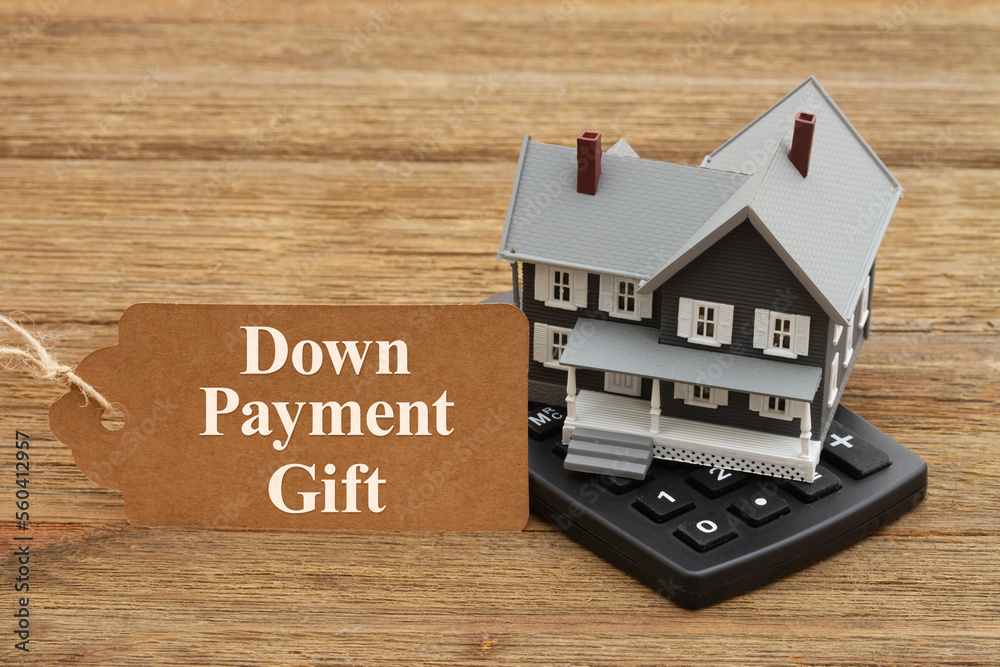 Down Payment Gift rules with a mortgage calculator on a wood desk Down Payment Gift rules with a mortgage calculator on a wood desk