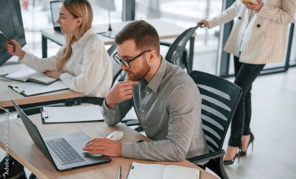© standret - Side view of man that is sitting. Successful team are working together in the office. Conception of business © standret - Side view of man that is sitting. Successful team are working together in the office. Conception of business