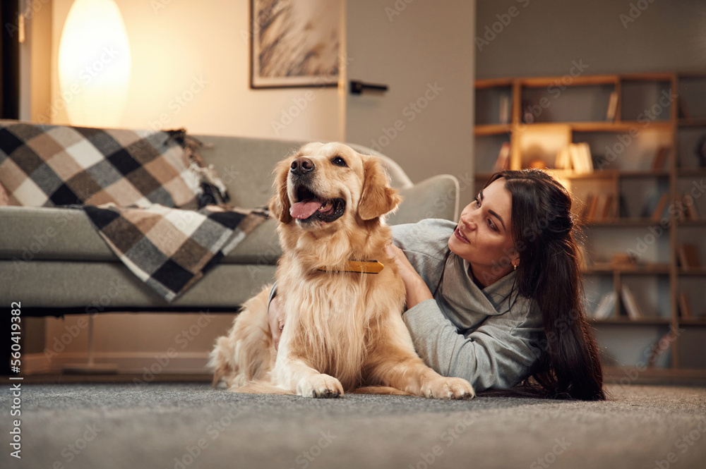 Lying down on the floor. Woman is with golden retriever dog at home Lying down on the floor. Woman is with golden retriever dog at home