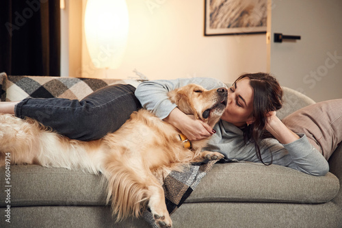 Wallpaper Mural Lying down on the sofa together. Woman is with golden retriever dog at home Torontodigital.ca