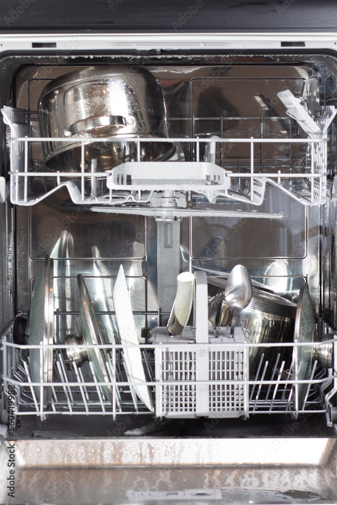 Clean plates after washer in the opened dishwasher.
