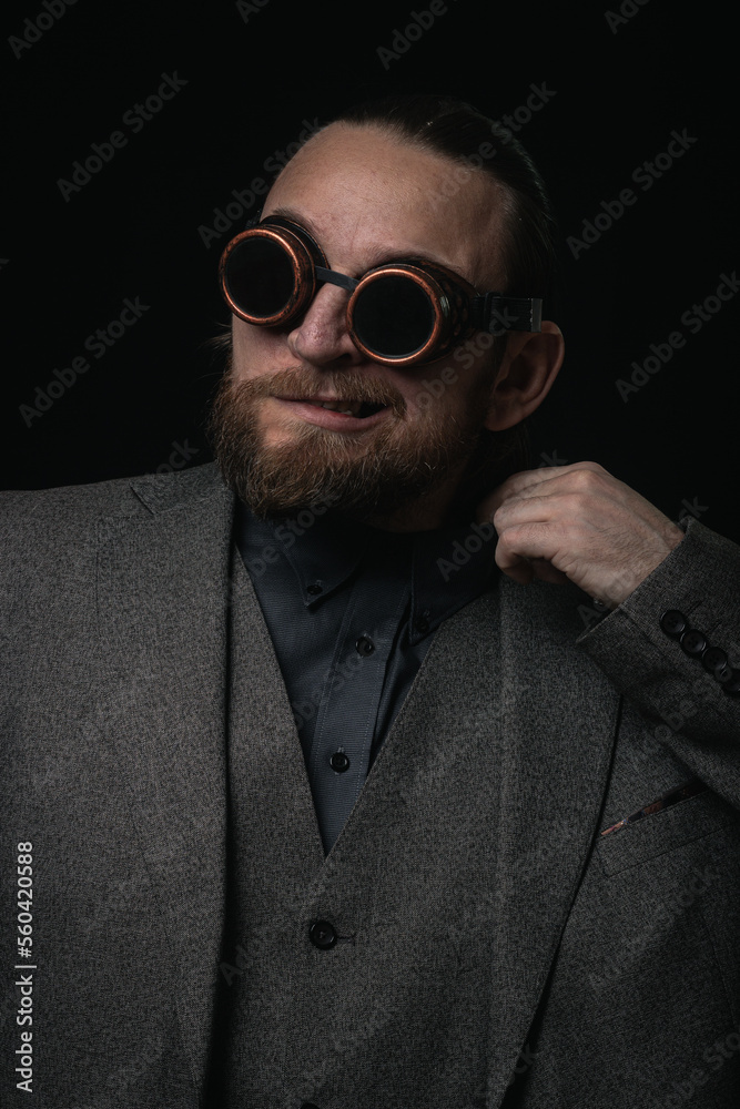 charismatic man in a classic suit and steampunk goggles on a black background stylish Portrait charismatic man in a classic suit and steampunk goggles on a black background stylish Portrait