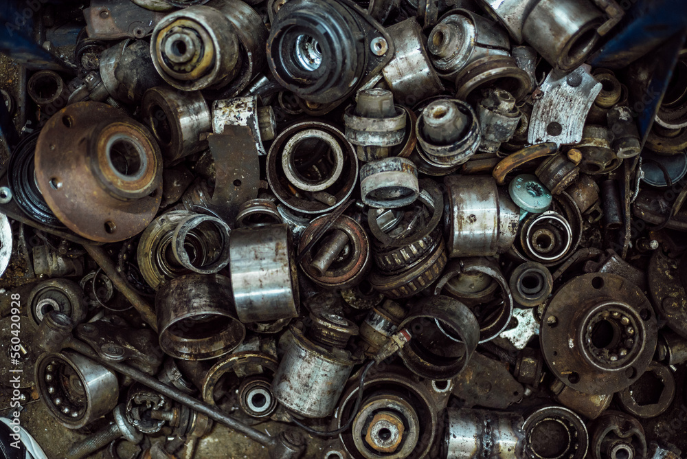 a large number of old rusty and oil-stained car parts