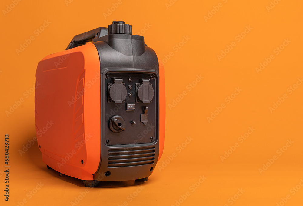 Electricity generator. Inverter gasoline generator on an orange background. Studio shot.