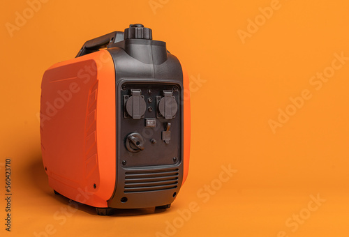 Obraz na płótnie Electricity generator. Inverter gasoline generator on an orange background. Studio shot. w salonie