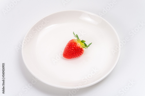 白いお皿に置かれた1個のイチゴ
