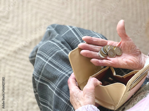 財布から出した小銭を手の平にのせた高齢女性 photo