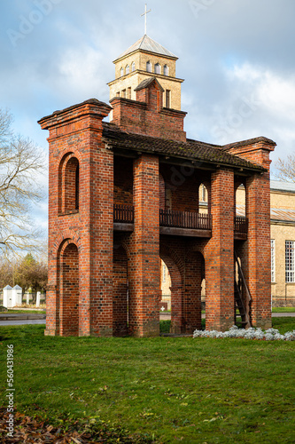 Old Catholic Church and red brick gates in city Akniste, Latvia photo