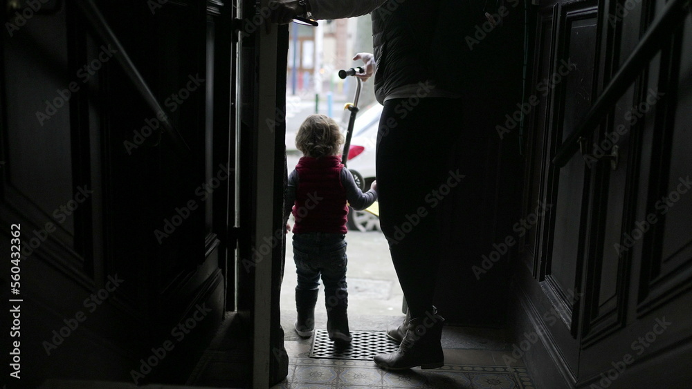 Mother and baby child stepping outside. Parent and toddler going out opening front door