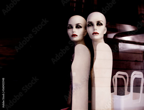 Two mannequins in a showcase on a dark background. copyspace