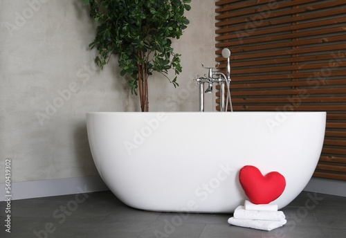 Wallpaper Mural Modern bathroom interior design with concrete walls, wooden slats and white bathtub. towels and heart. Valentine's day concept, relaxation, massage, gifts, care, rest. Torontodigital.ca