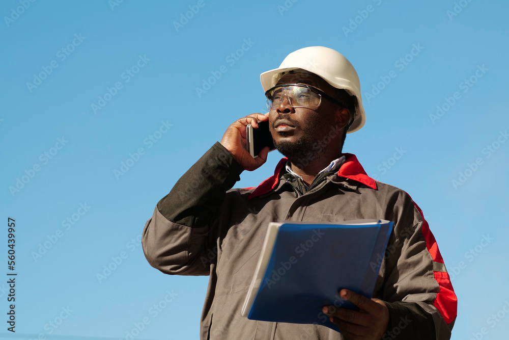Busy african american works manager with work papers talks on smartphone Busy african american works manager with work papers talks on smartphone