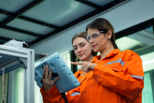 Both of woman in an electronic parts factory Using a production line controller and are recommending colleagues to use this tool.