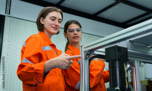 Both of woman in an electronic parts factory Using a production line controller and are recommending colleagues to use this tool.