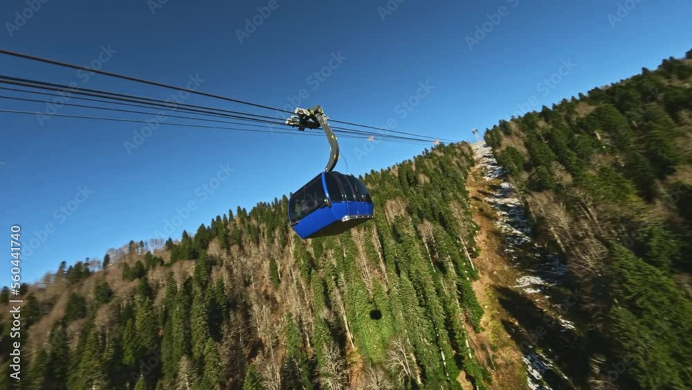 Fpv drone shot around blue ropeway big cabin over yellow winter pine ...