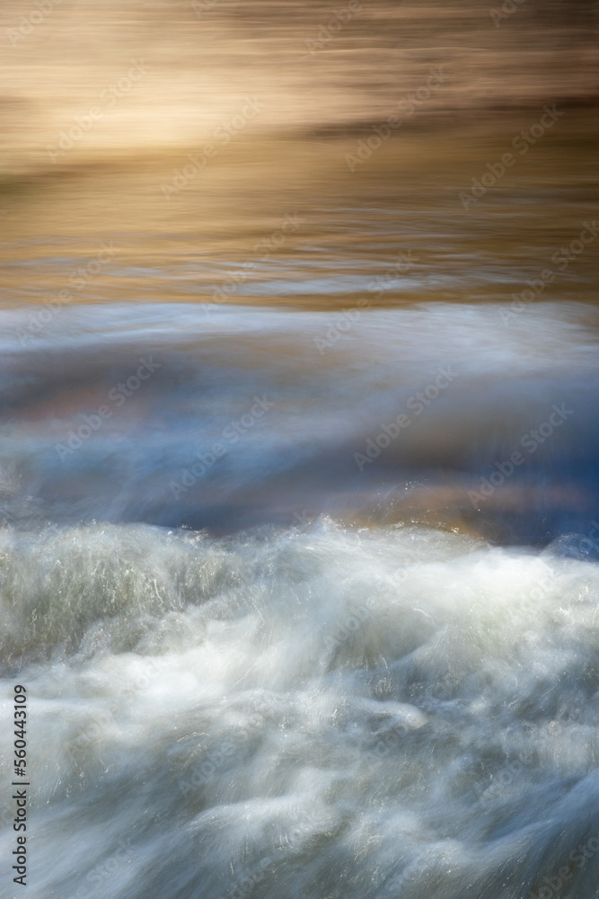 Moving river water on blue and brown background. Slow shutter speed. Dreamy image. World Water Day concept. Copy space. 