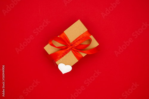 On red background craft box with red ribbon. A gift for Valentine's Day © Jenya Smyk