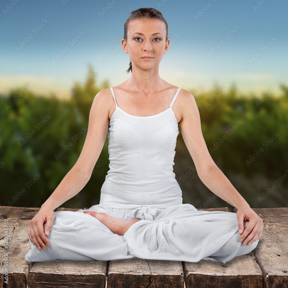 Young happy woman do yoga. meditating on outdoor