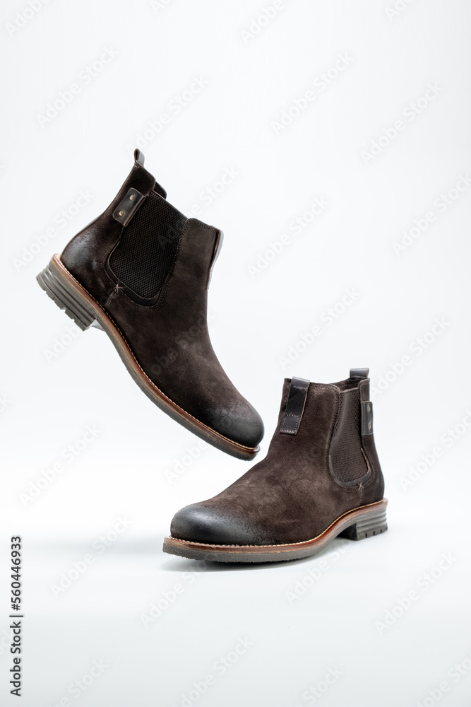 Flying men brown suede casual style boots over white background. side view. Copy space for ad, design, text.