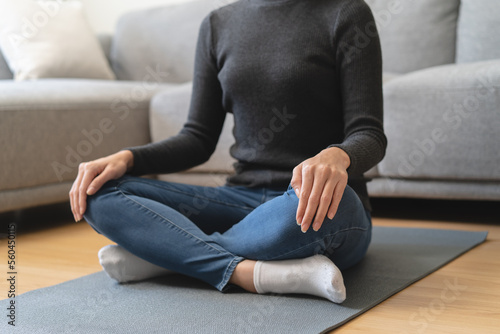Young woman sitting on the floor and doing meditation practice mindfulness at home