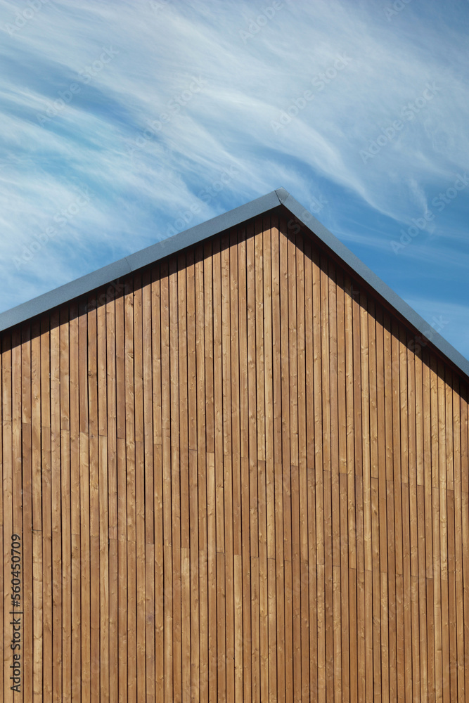 Fototapeta premium Roof construction with wooden plank gable on a new modern home. Copy space, vertical