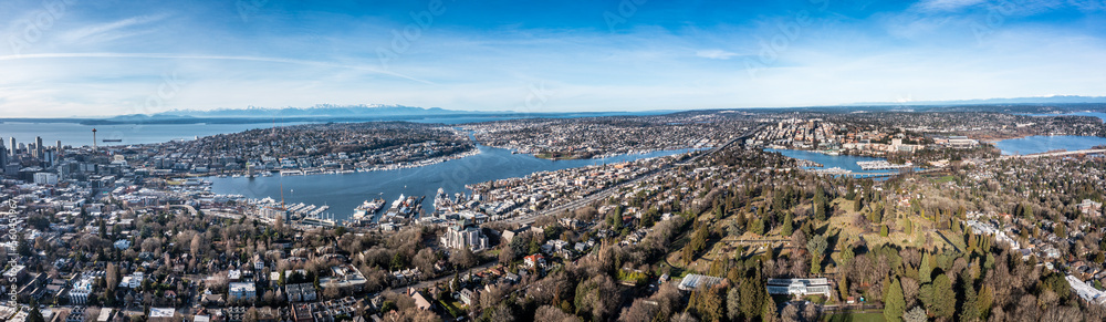 Seattle, Washington - Jan. 2023, panoramic aerial landscape view of the area around Lake Union and Lake Washington in Seattle with Space Needle and snow covered Mountains in background