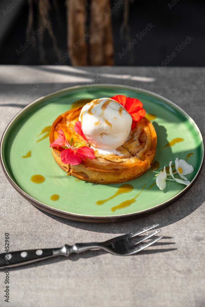 Round Apple Pie or Tart Topped with Ice Cream Ball and Sweet Sauce. crispy mini cake decorated with flower leaves on a light background Round Apple Pie or Tart Topped with Ice Cream Ball and Sweet Sauce. crispy mini cake decorated with flower leaves on a light background