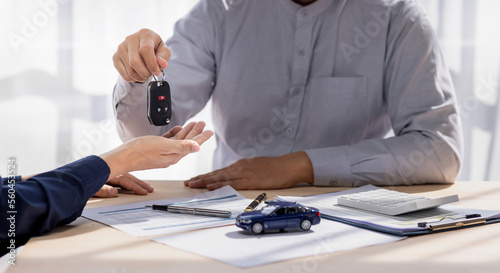 Canvas Print Dealer salesman giving car key to owner