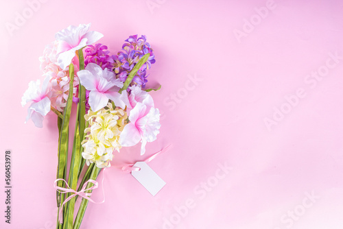 Spring flowers bouquet, Valentine's day card, International Women's Day on March 8, Mother's day. Hyacinth, narcissus, tulip, with a pink gift ribbon and tags for wishes, on pastel background