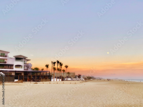 Beach during sunset with moon visible in the sky as taken in this photo from Cabo San Lucas, Mexico
