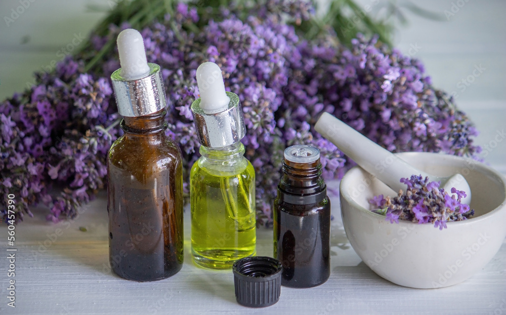 A bottle of essential oil with fresh blooming lavender twigs A bottle of essential oil with fresh blooming lavender twigs